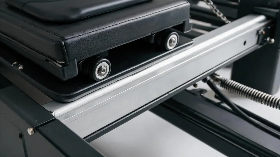Macro detail of k30 reformer carriage wheels running on an aluminium rail