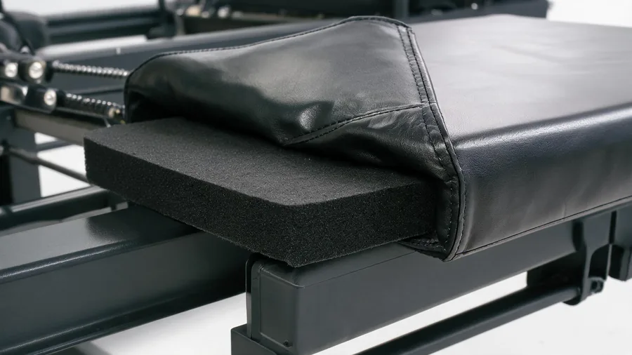 Pilates reformer foam padding: comfort keeps clients 1 Macro detail of reformer carriage foam padding under vinyl upholstery